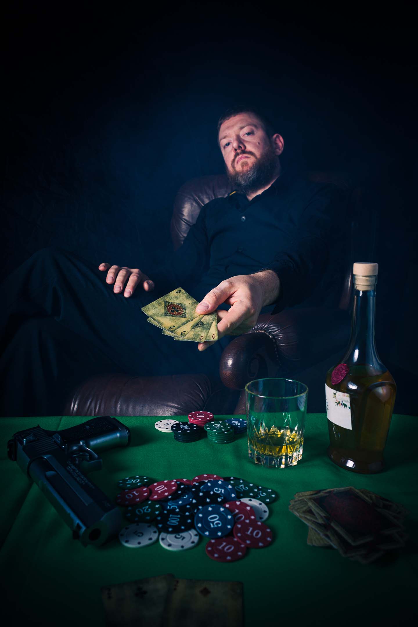 Narrative staged studio portrait, noir poker scene with cards and chips