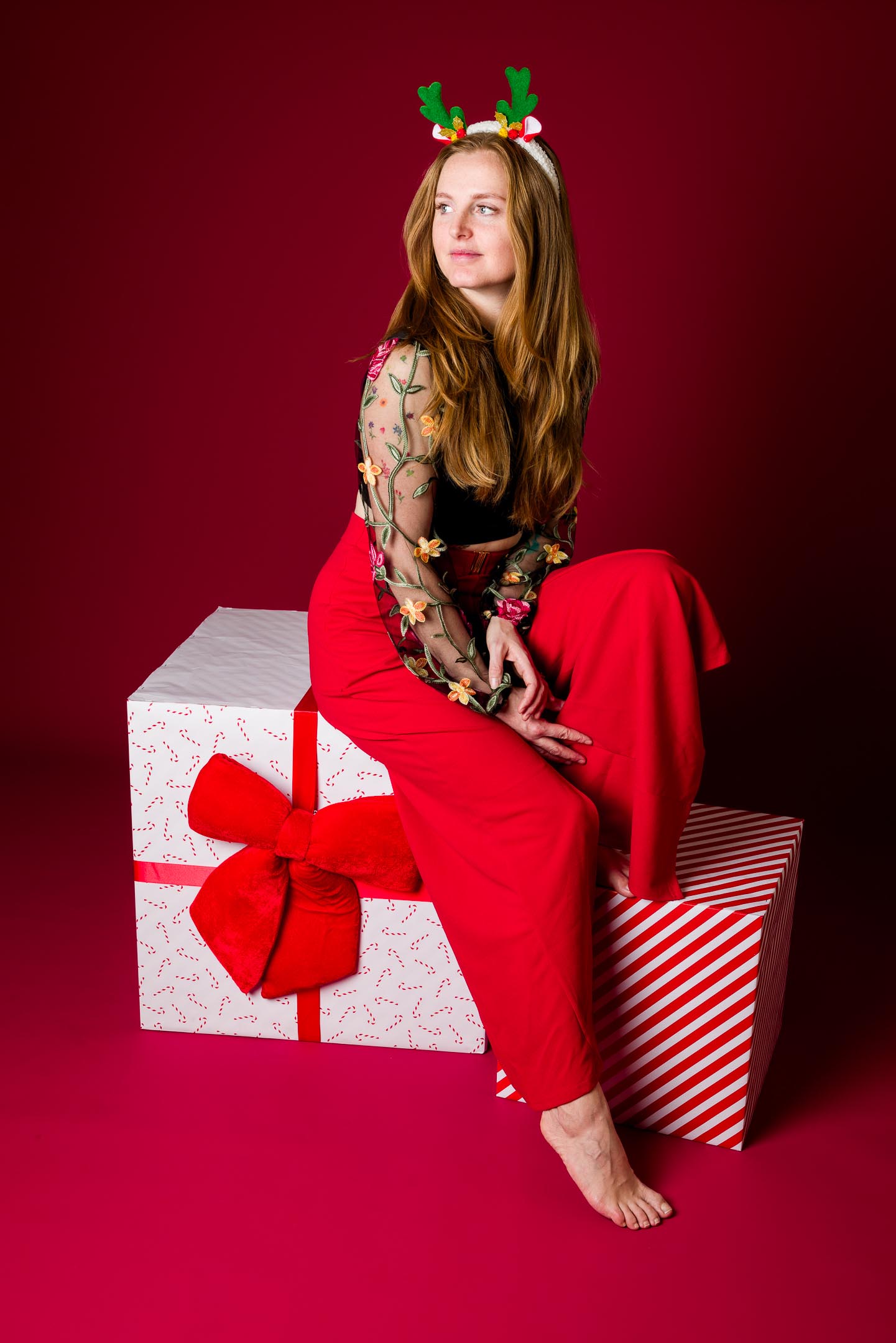 Narrative staged studio session with a red seasonal backdrop